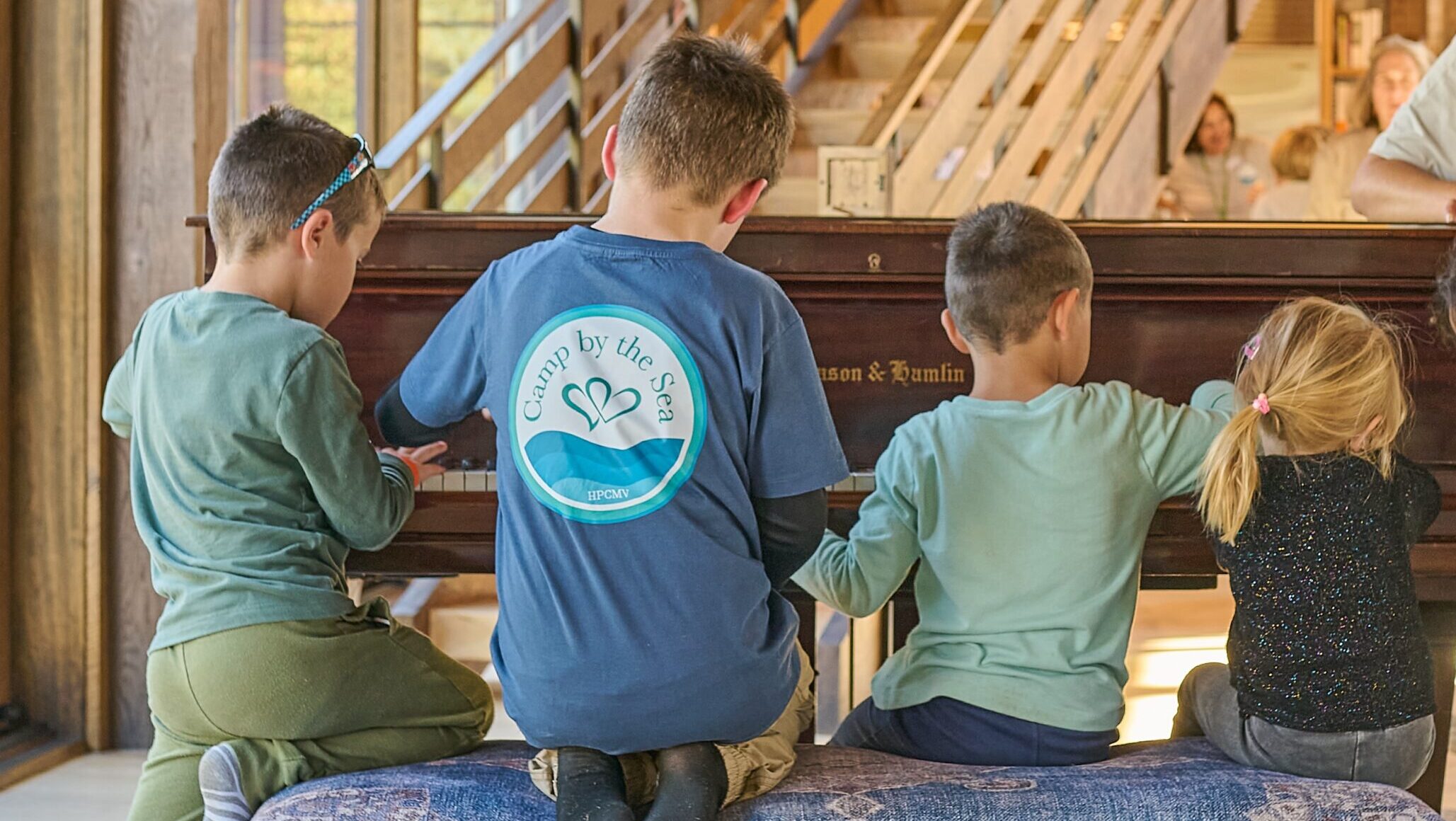 Four Children at Camp By The Sea playing the piano at Slough Farm