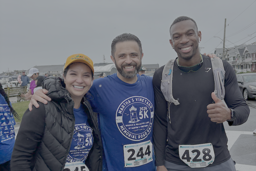 a woman and two men smiling, who just crossed the finish line