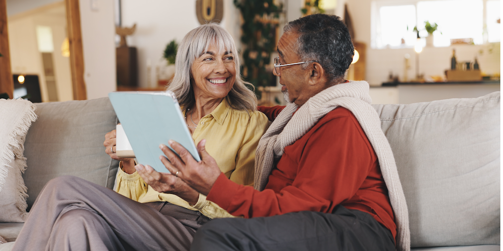 happy senior couple looking at tablet screen
